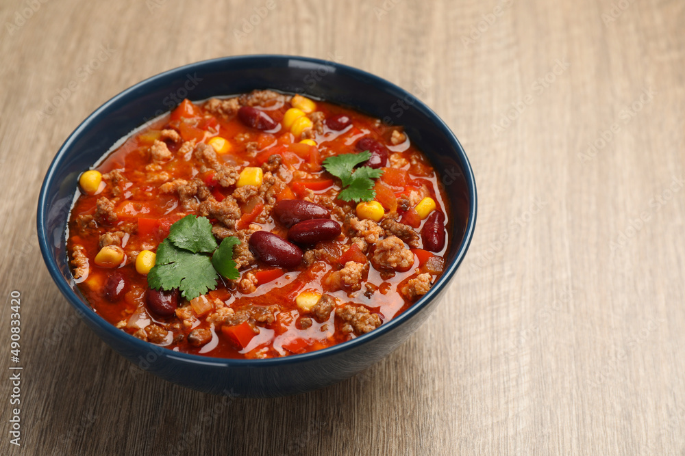 Bowl with tasty chili con carne on wooden table, closeup Bowl with tasty chili con carne on wooden table, closeup