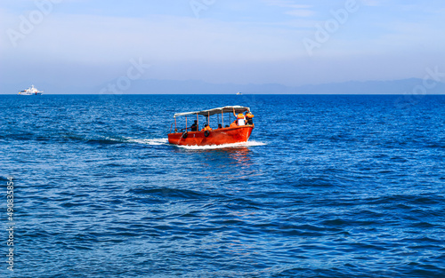 Small tourist boat with passengers. Beautiful seascape with a tourist boat. © NadimMahmudHimu