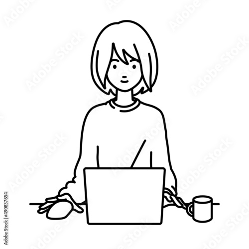 デスクで座ってPCを使っているリモートワークの女性