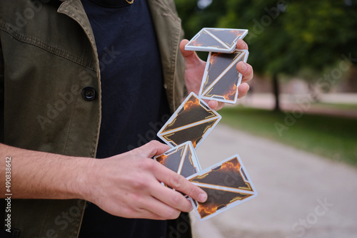 Detail of the hands of a street magician shuffling the cards in the street