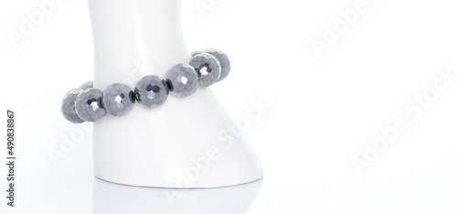 Terahertz bracelet on a white display stand. Terahertz stone can increase blood circulation and stimulate metabolism and rejuvenation. Collection of natural gemstones accessories. Studio shot photo