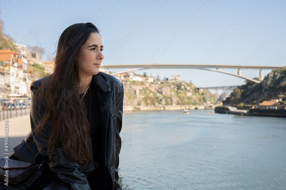 Portait young woman in a city overlooking river and bridge . Portait young woman in a city overlooking river and bridge .