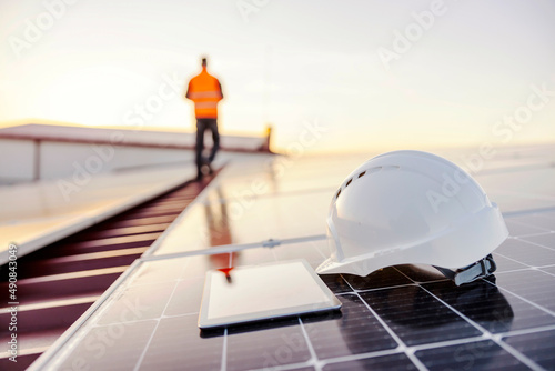 A helmet and tablet on solar panel on rooftop. photo