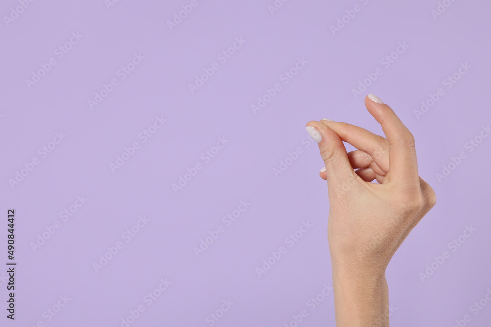Woman snapping fingers on violet background, closeup of hand. Space for text