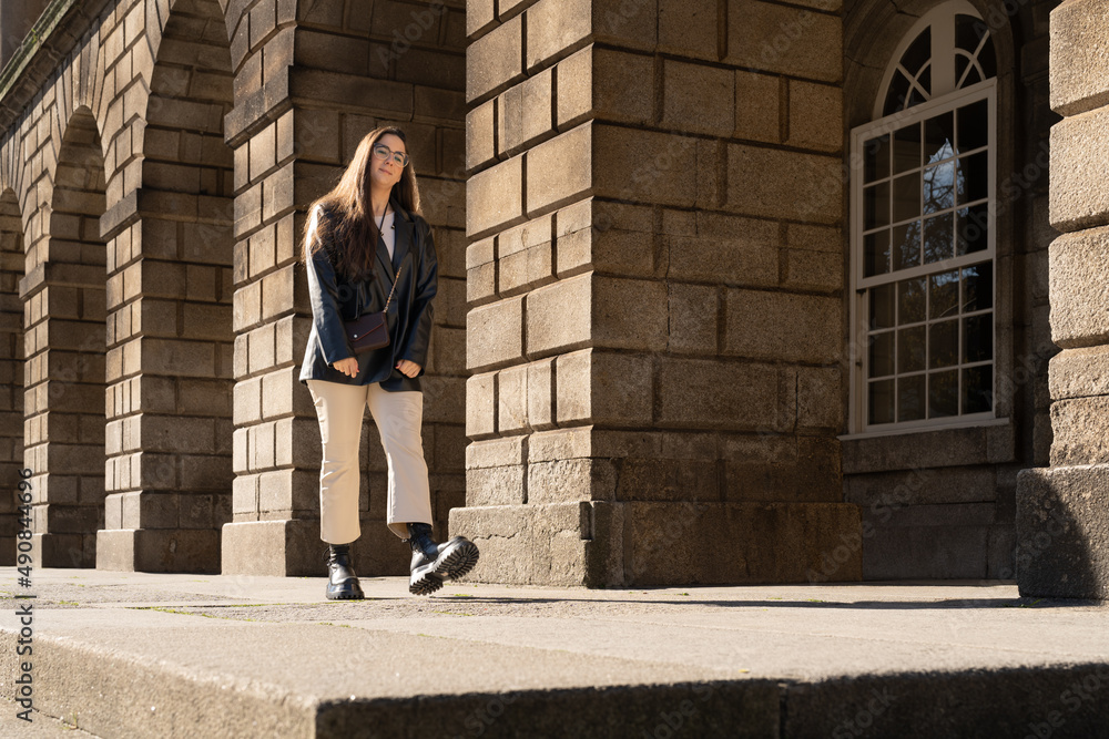 Young woman walking next to some historical arches Young woman walking next to some historical arches