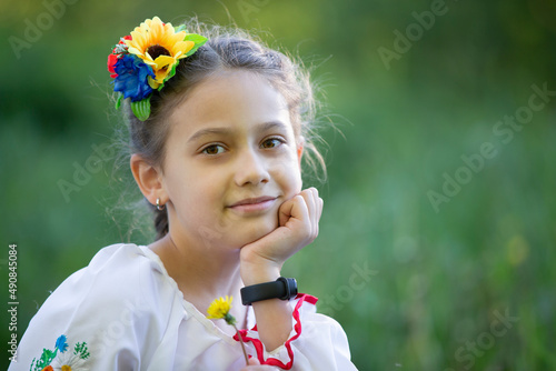 Murais de parede A little Ukrainian and Belarusian girl in an embroidered shirt on a summer background