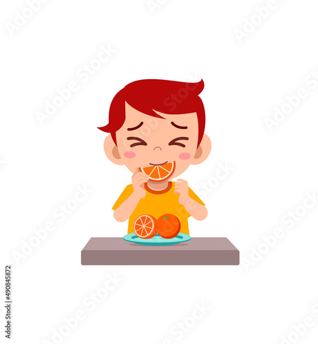 little boy eat sour orange and show funny expression