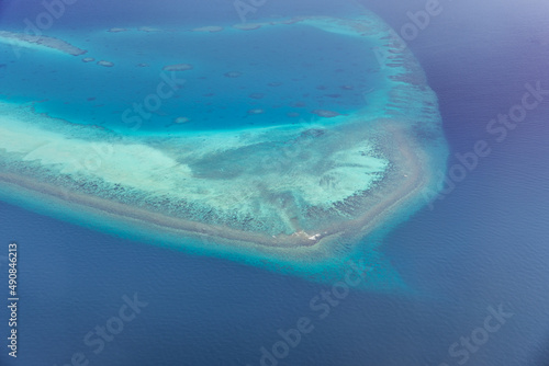Tropical islands and atolls in Maldives from aerial view. Famous travel destination and luxury vacation or summer holiday concept. Aerial landscape of blue sea and resorts, hotels. Gorgeous nature