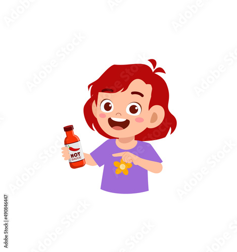little girl holding a bottle of hot sauce