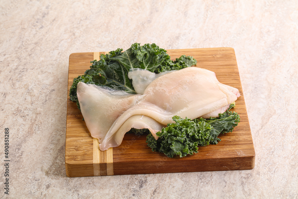 Raw squid over wooden board