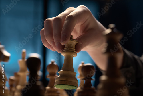 Man playing chess game and moving the queen