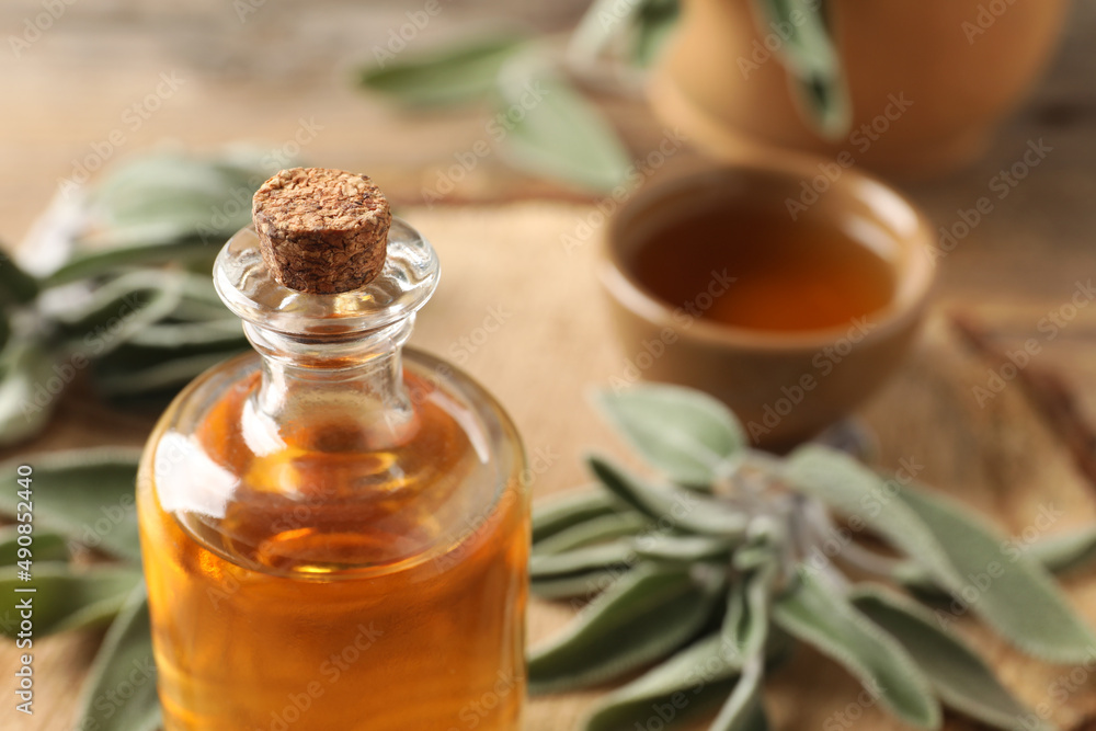 Bottle of essential sage oil on table, closeup. Space for text Bottle of essential sage oil on table, closeup. Space for text