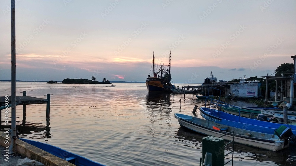 Fototapeta premium sunset seen from the port of alvarado with fishing boats in the background