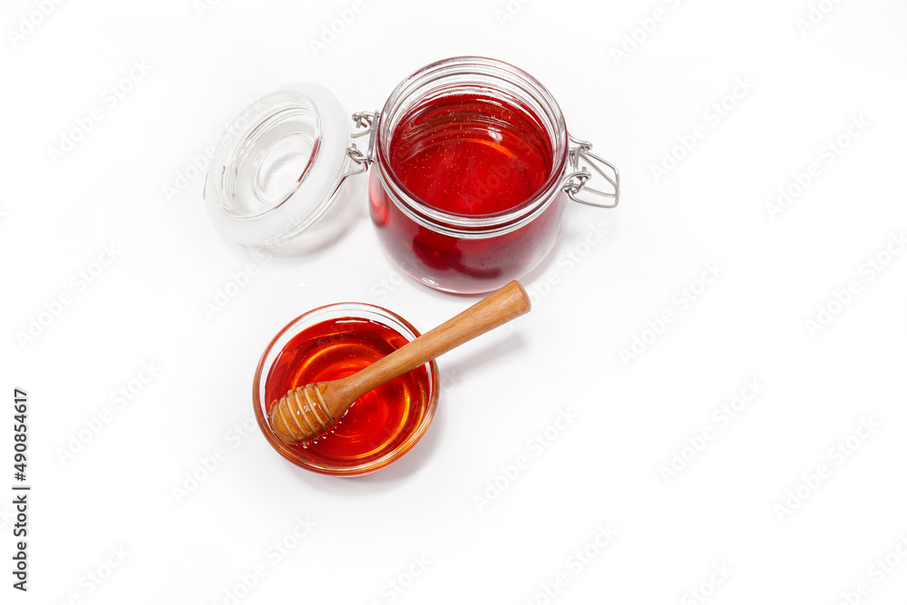 glass jar filled with honey on a white background glass jar filled with honey on a white background