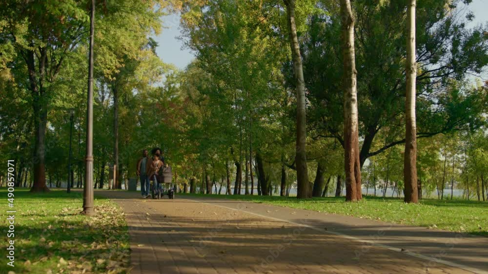 Idylic family walking park on warm autumn day. Older sister caring of newborn. Idylic family walking park on warm autumn day. Older sister caring of newborn.