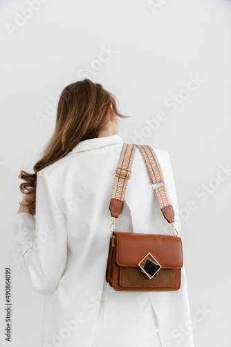 A few colorful stylish handbags. fashionable women's leather clutch bag. Traditional women's clutch bag with gold fittings made of fine colored leather. A girl is advertising a bag. Young blonde girl 
