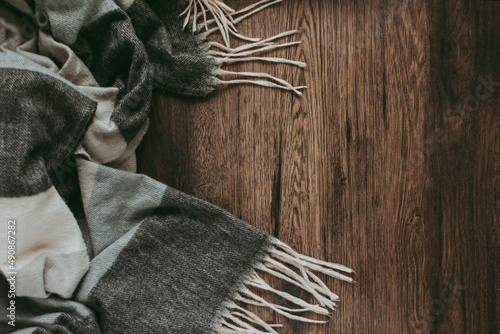 Autumn background. Beautiful gray scarf on a wooden background. Flat lay, top view