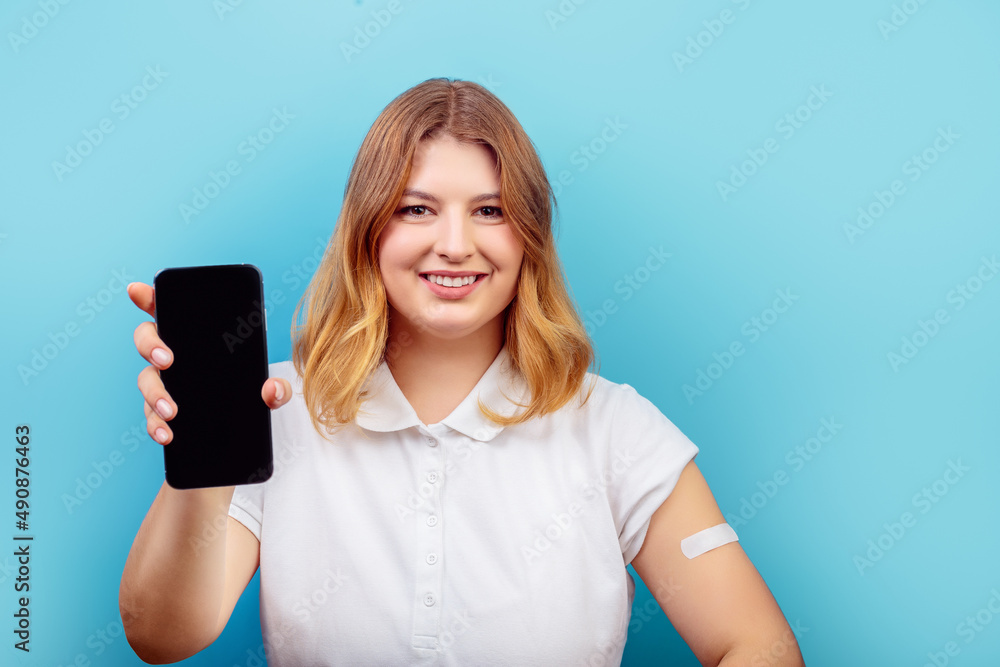 Photo of young lovely woman show mobile screen advertise advise choice proposition isolated over blue color background COVID 19 vaccination concept Photo of young lovely woman show mobile screen advertise advise choice proposition isolated over blue color background COVID 19 vaccination concept