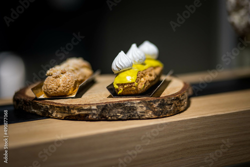 Pâtisseries françaises artisanales, éclaire au café et au fruit surmonté d'une meringue dans une boulangerie photo