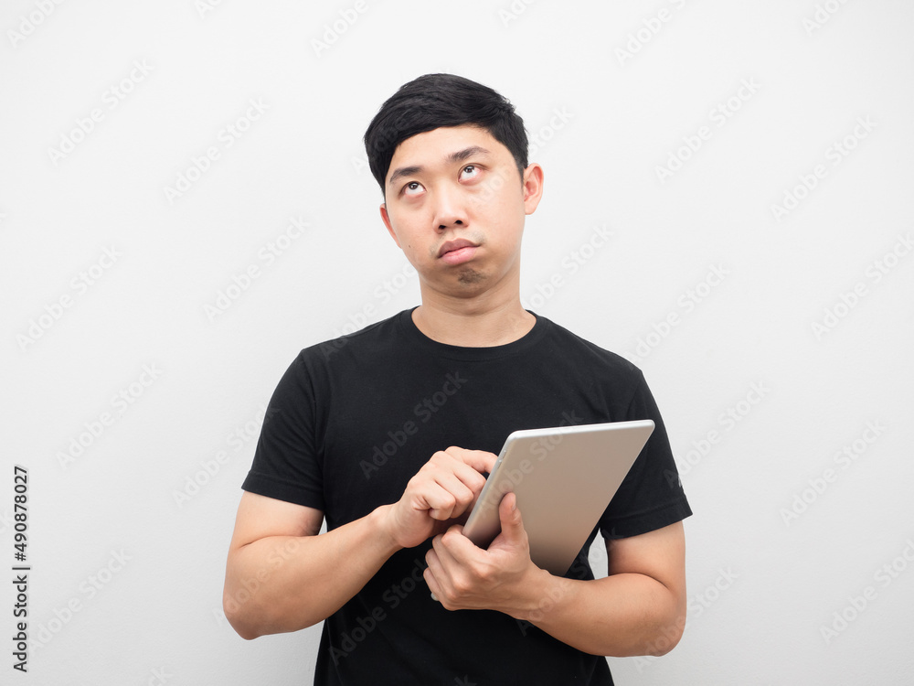 Man using tablet feeling bored and looking up Man using tablet feeling bored and looking up