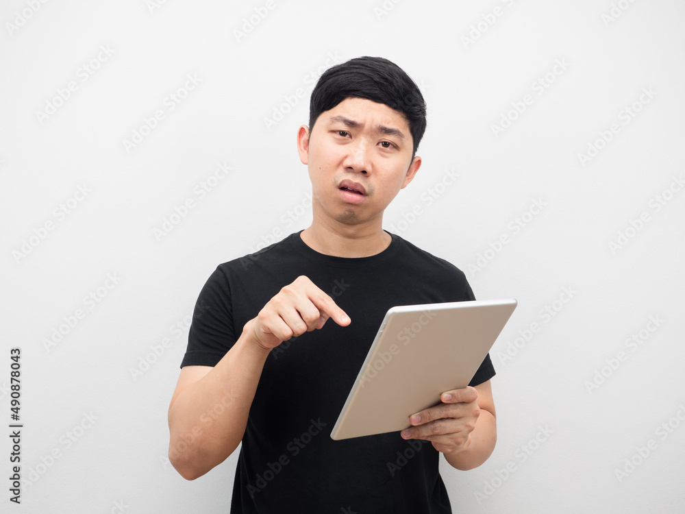 Man point finger at tablet in hand with serious emotion Man point finger at tablet in hand with serious emotion