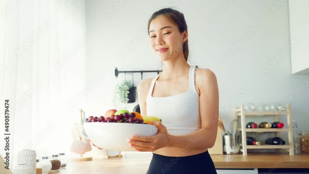 Portrait of Asian attractive woman hold fruit bowl and look at camera. Portrait of Asian attractive woman hold fruit bowl and look at camera.