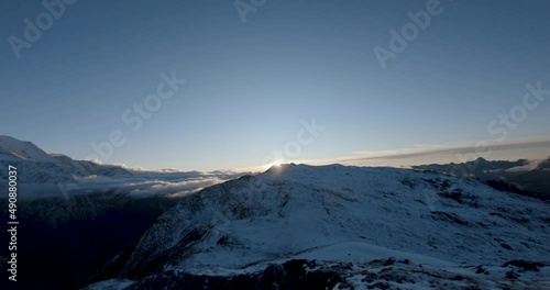 FPV drone over snowy mountains at sunset