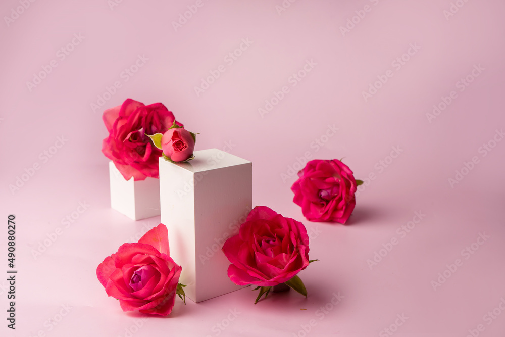Fototapeta premium Podium for product photo background with roses. geometric objects and flowers.