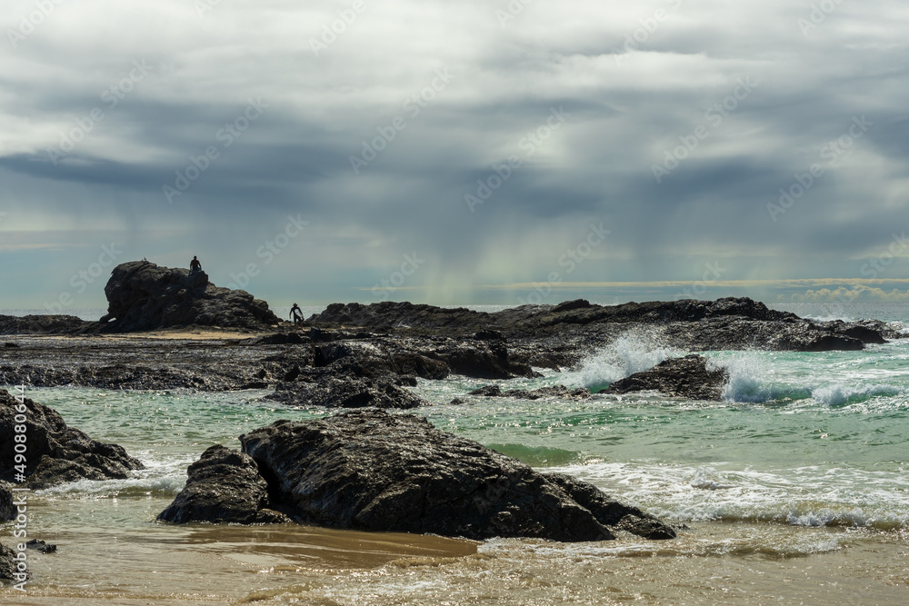 Rocks and sea on a rainy day at Currumbin Beach, Gold Coast, Queensland, Australia. 