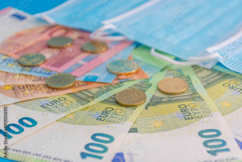 Medical masks and Euro currency banknotes. Financial crisis due to Coronavirus losses, selective focus