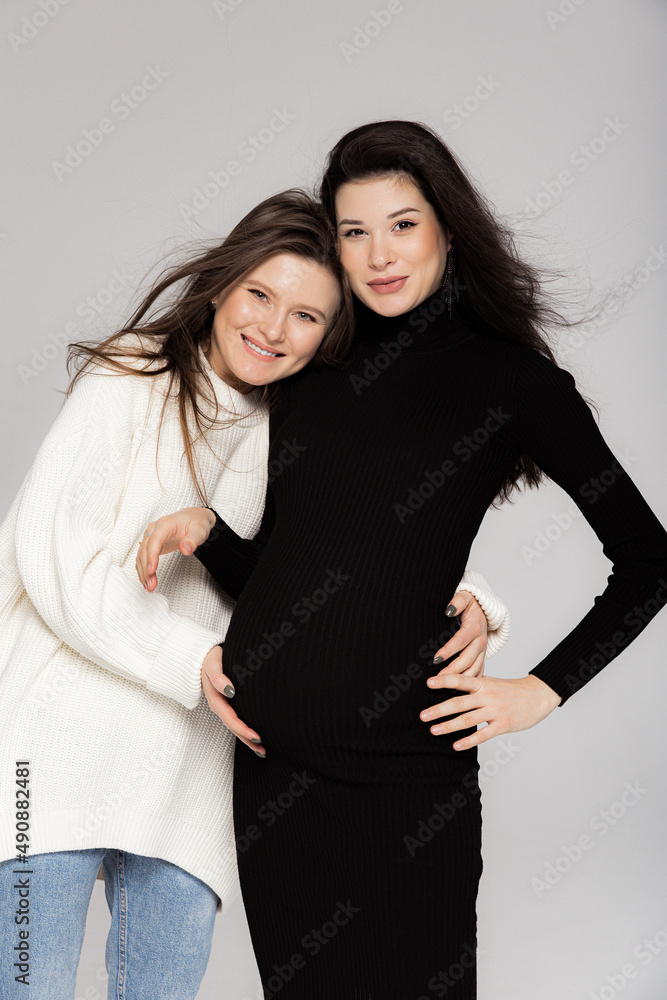 Stylish pregnant brunette in black dress with a throat and her friend Stylish pregnant brunette in black dress with a throat and her friend