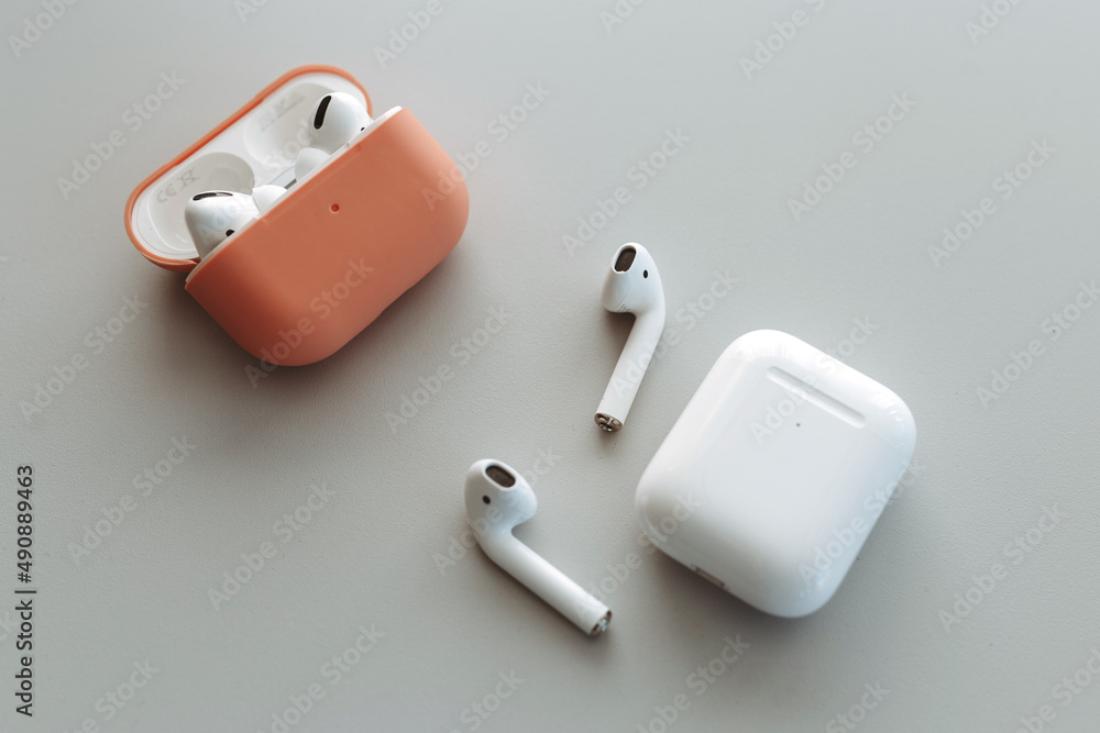 Fototapeta premium White wireless bluetooth earphones or headphones, plastic case or box for storage and charging