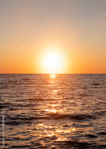 Sunset with yellow sun at the horizon at sea © ArtmediaworX