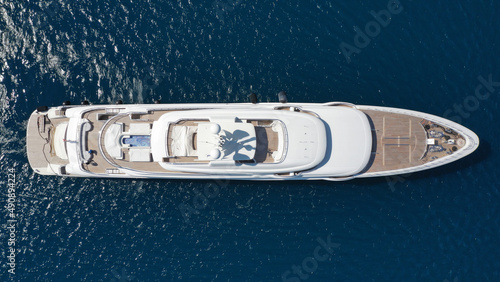 Aerial drone ultra wide photo of luxury yacht with wooden deck and helipad anchored near port of Port of Fontvieille in deep blue sea, Monaco, France © aerial-drone