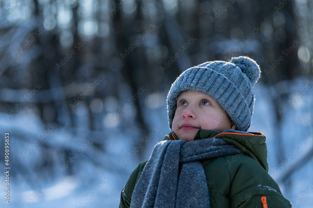 little boy walking in the woods in winter