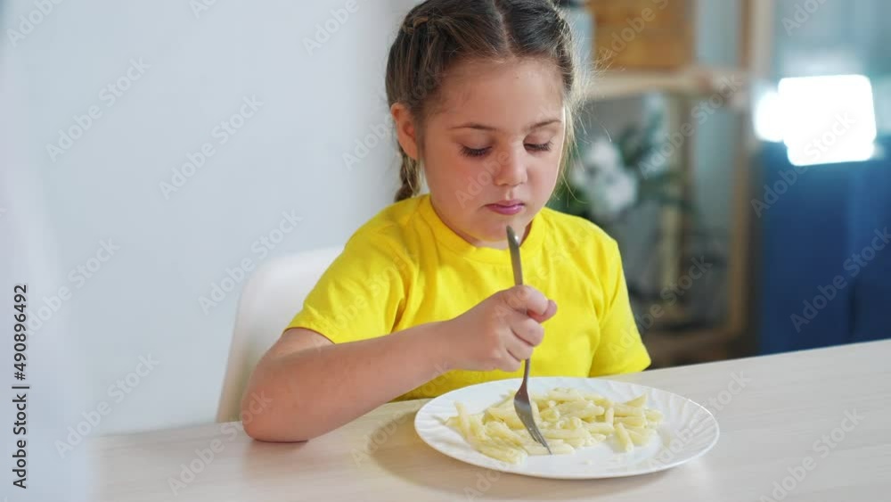 child eating pasta. healthy a food vegetarianism concept. girl child at the table in the kitchen eating pasta. kid eating pasta. indoor little girl at the table eats short pasta spaghetti child eating pasta. healthy a food vegetarianism concept. girl child at the table in the kitchen eating pasta. kid eating pasta. indoor little girl at the table eats short pasta spaghetti