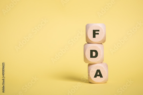 FDA, U.S. Food and Drug Administration Acronym on Wooden cubes isolated on Yellow copy space