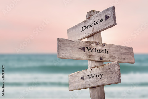 decide which way text quote written on wooden signpost by the sea. Positive pink turqoise pastel theme.