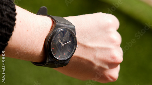 person looking at the time on the black watch