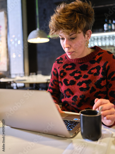 Manager of a restaurant working with a laptop inside the business