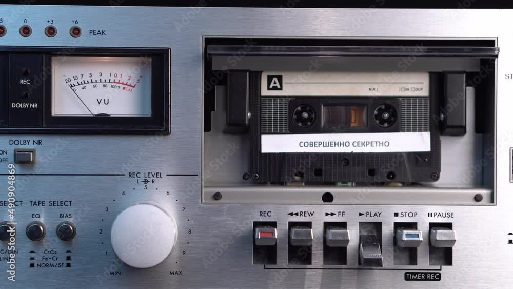 Russian Top Secret Audio Cassette Tape, Hand Placing Recording in Deck and Pressing Play Button, Close Up Russian Top Secret Audio Cassette Tape, Hand Placing Recording in Deck and Pressing Play Button, Close Up
