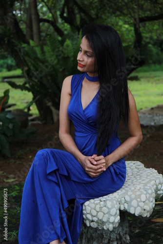 Beautiful girl in a long blue dress. A young woman of Asian descent with black hair