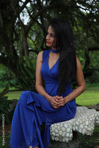 Beautiful girl in a long blue dress. A young woman of Asian descent with black hair