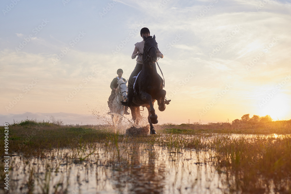 Horses lend us the wings we lack. Shot of two young women riding their horses outside on a field. Horses lend us the wings we lack. Shot of two young women riding their horses outside on a field.
