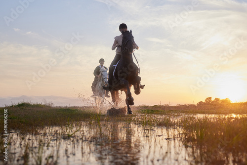 Horses lend us the wings we lack. Shot of two young women riding their horses outside on a field. © peopleimages.com