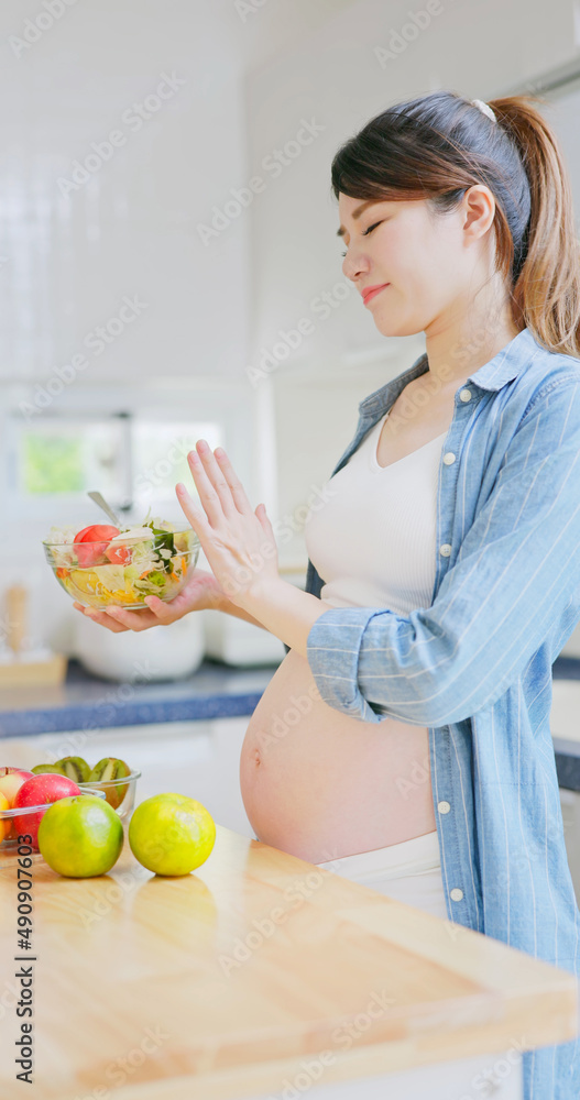 Asian pregnant woman prepare salad