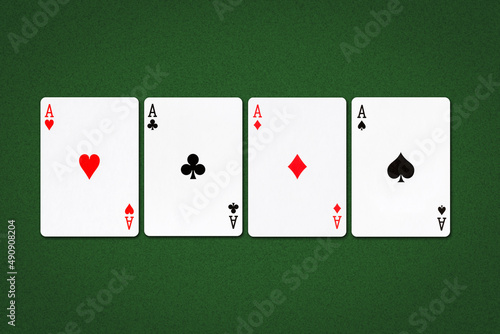 Four aces, different suits on a dark green poker background. Gambling background.