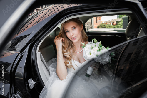 Stylish bride in a wedding car. Bridal bouquet