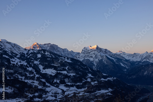 A mountain in the Swiss Alps beautifully set in scene by the morning sun. A majestic sight from a mountain that looks like the Matterhorn.