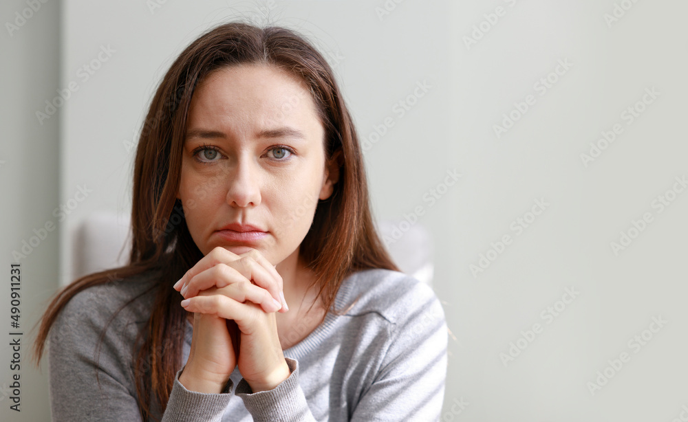 Upset young woman sitting on couch alone at home Upset young woman sitting on couch alone at home